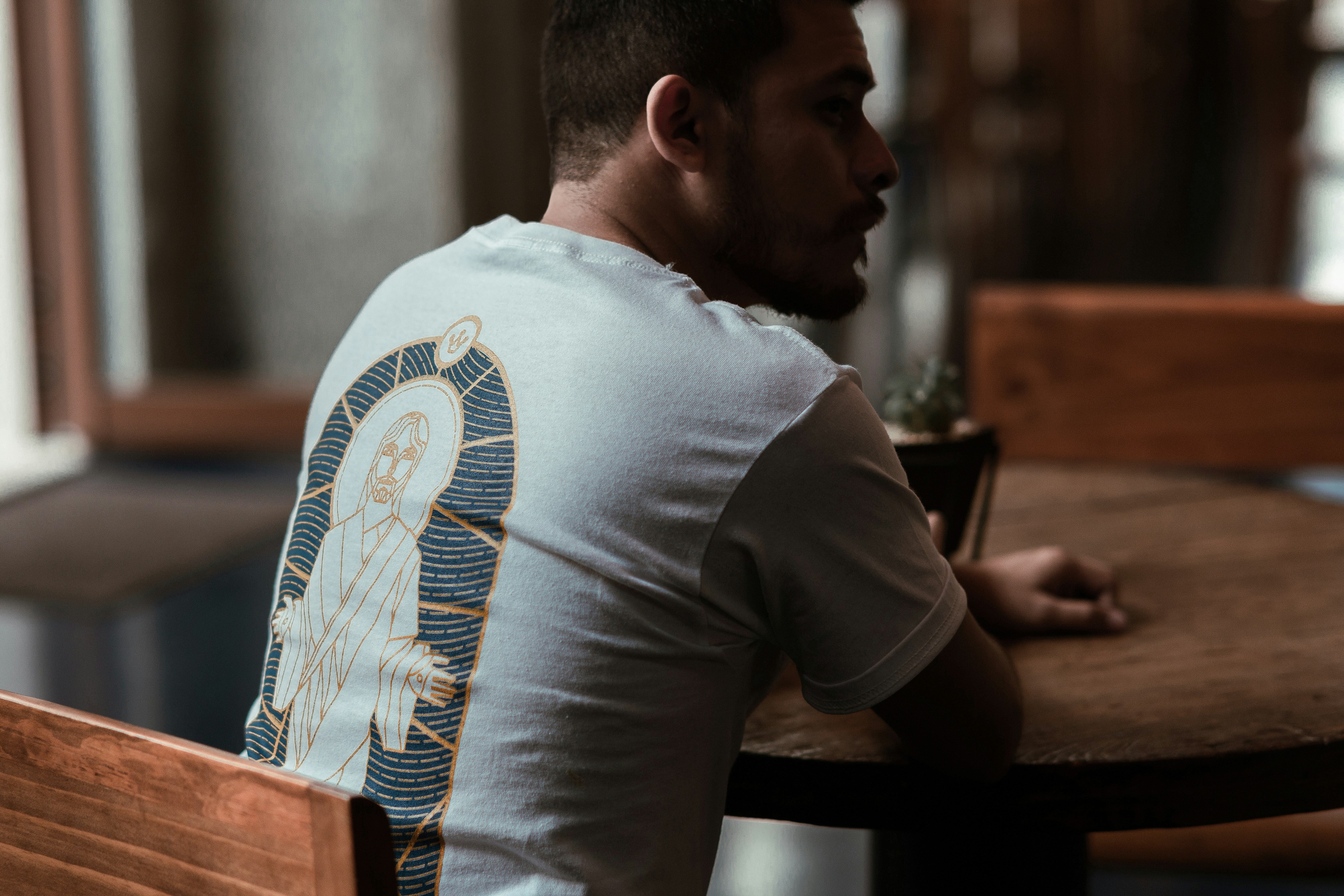 man in white t-shirt sitting at the table