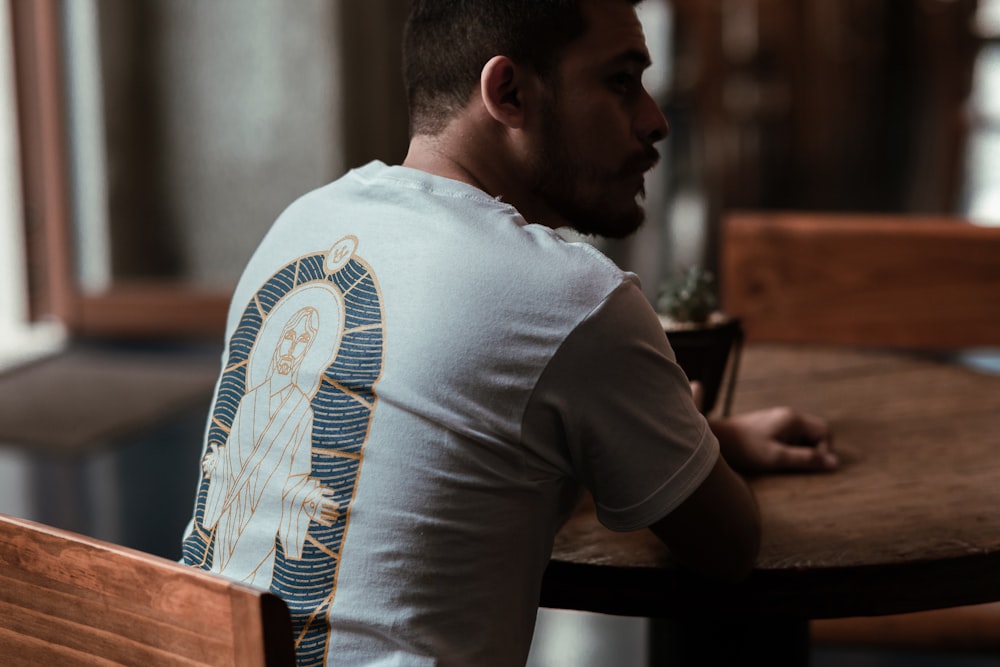 man in white t-shirt sitting at the table