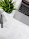 A well-organized workspace featuring a laptop, a potted plant, design sketches, and writing tools. The sketches appear to be wireframes for a 'Shopping Gift Voucher' application or website, drawn on white paper with annotations.