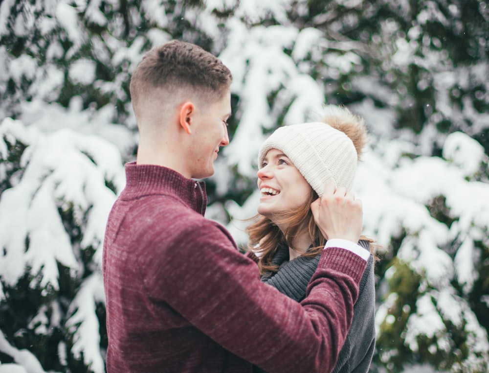 uomo sorridente davanti alla donna in maglione grigio