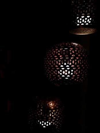 Close-up of an intricately designed pendant lamp casting delicate shadows on the walls.