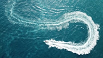 aerial photography of boat making zig zag way on body of water