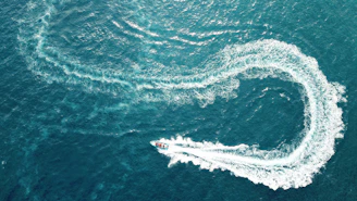 aerial photography of boat making zig zag way on body of water