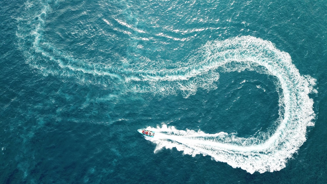 aerial photography of boat making zig zag way on body of water,