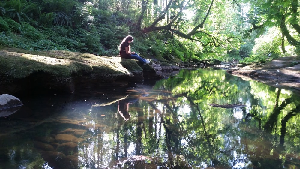 woman sitting beside body of water