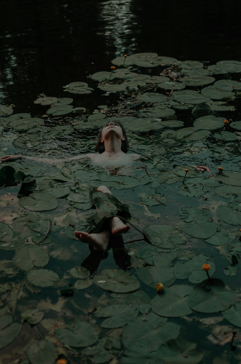 woman lying on body of water
