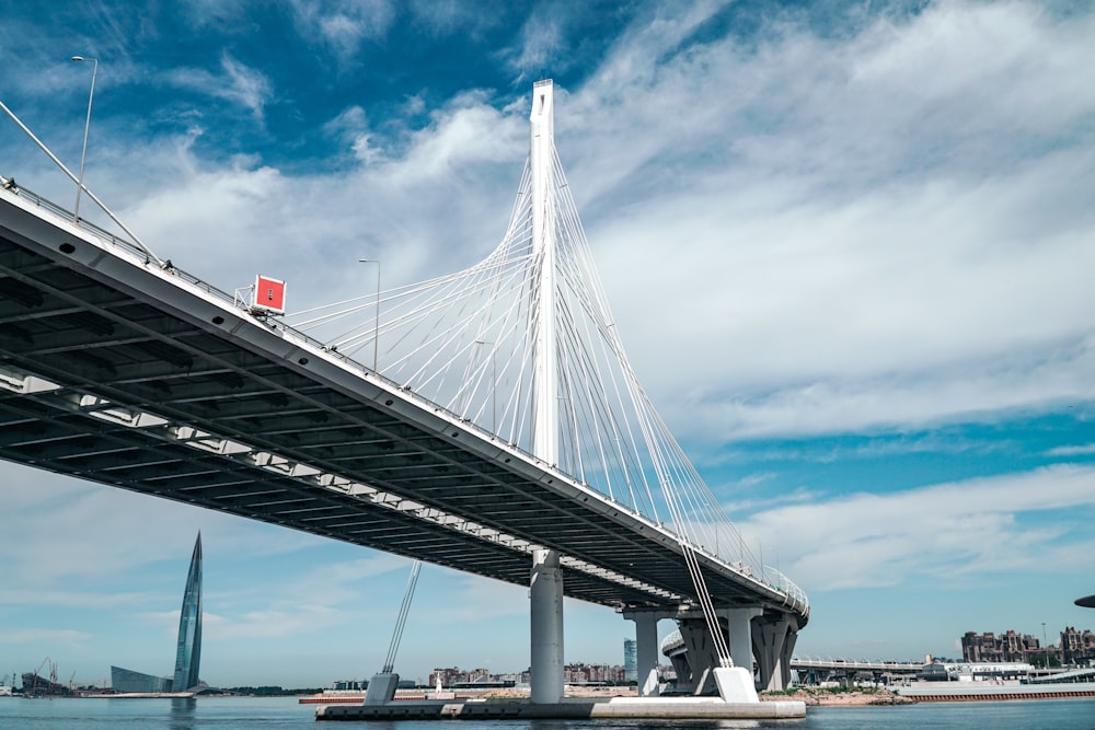 white bridge under white clouds and blue sky during daytime