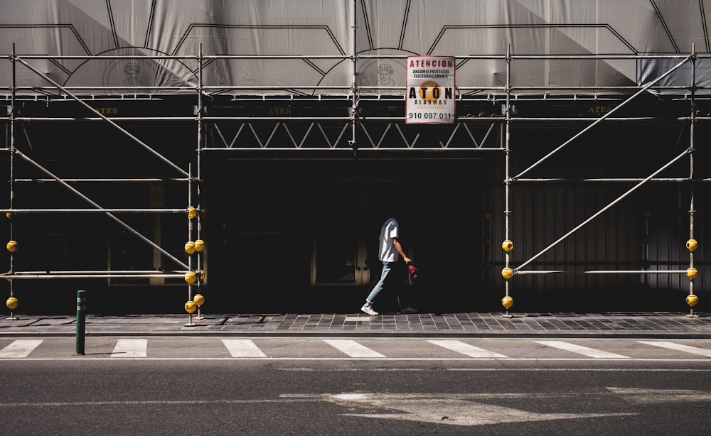 man walking in sidewalk across street