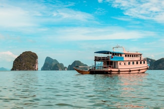 A vibrant boat cruising near lush green islands under a bright blue sky.