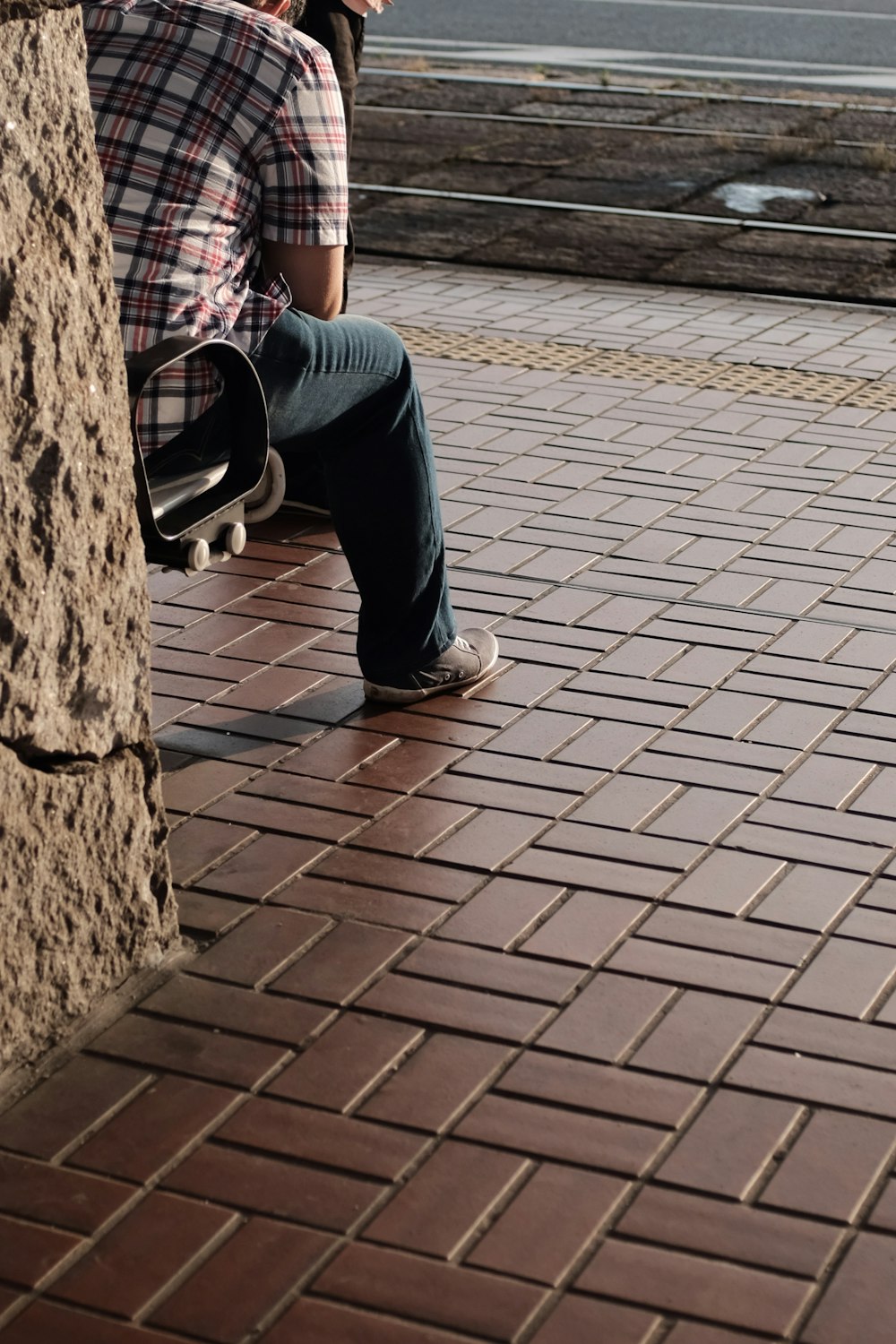 person sitting on black chair beside road during daytime
