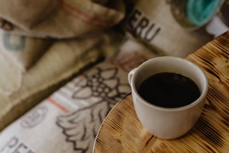 white ceramic mug on brown wooden table