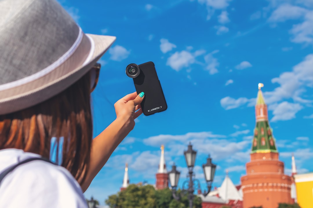 woman taking self portrait with clip-on zoom lens in smartphone