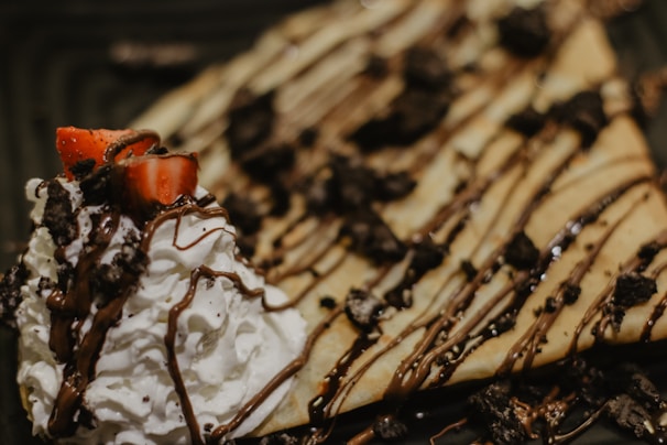 A delicious Nutella pizza with powdered sugar and fresh strawberries, perfect for dessert.