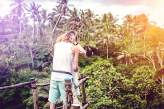 Photo of a cheerful couple sending a message from a tropical resort terrace.