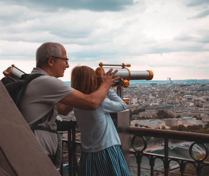 man and girl using telescope