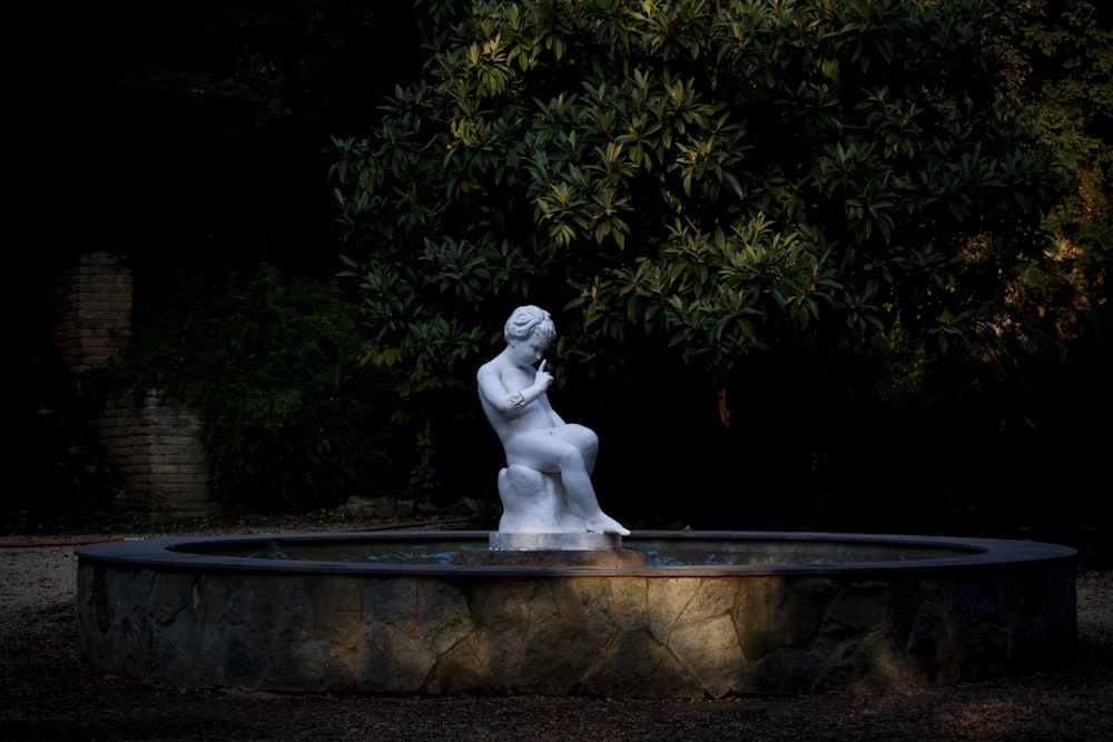 white nude boy statue on round fountain