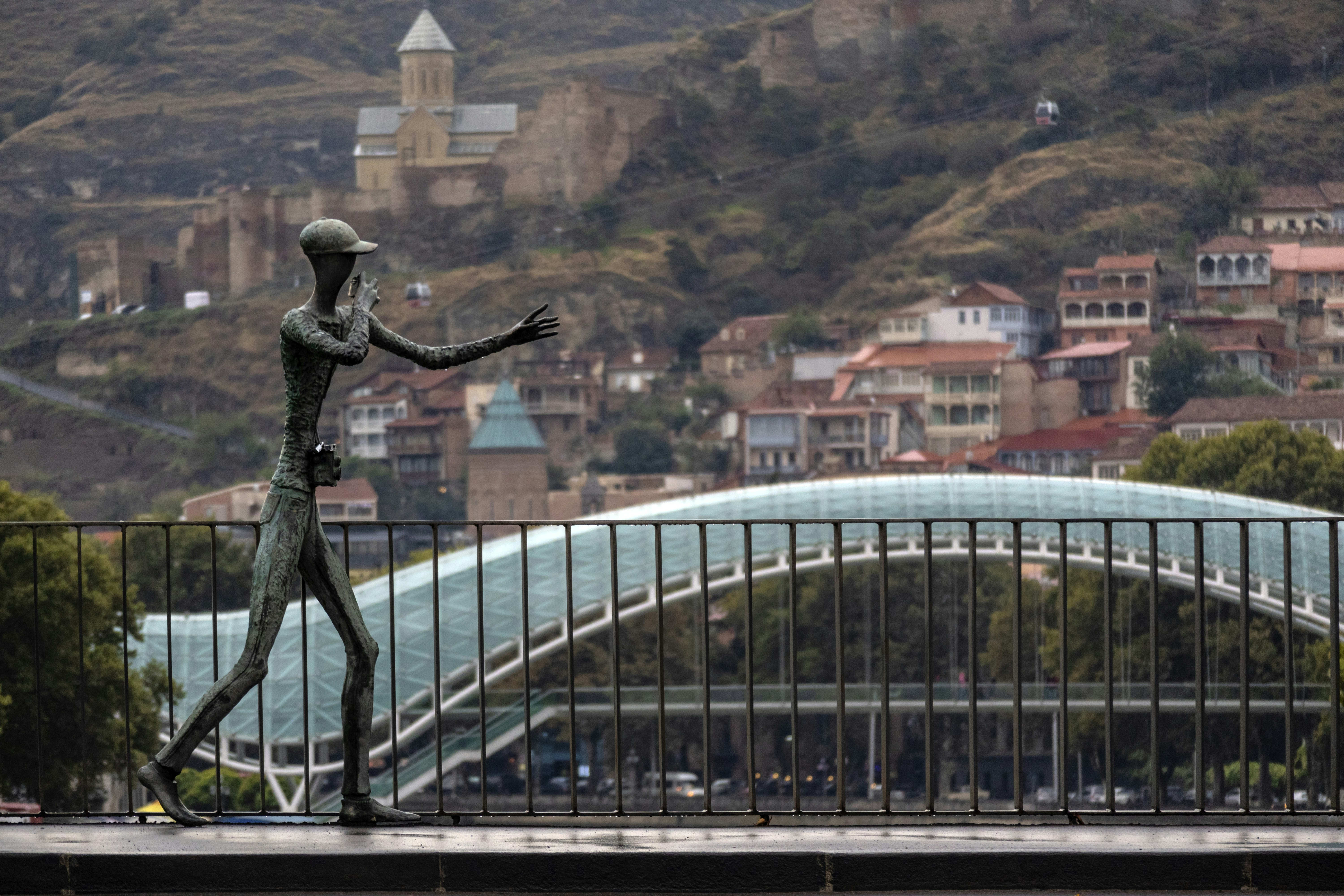 man statue beside fence, Located strategically in the heart of the Caucasus between Europe and Asia, Tbilisi became an object of rivalry among the region