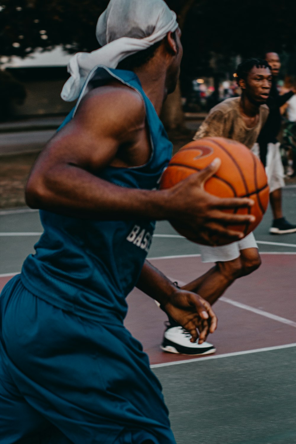 Homem em uniforme de basquete azul com bola na quadra