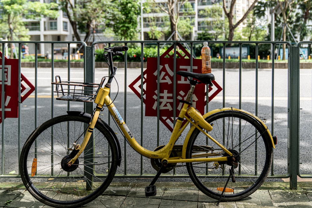Fahrrad neben Zaun in der Nähe der Straße geparkt