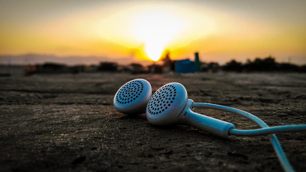Sunset behind traditional Albanian mountains with headphones resting on a wooden table.