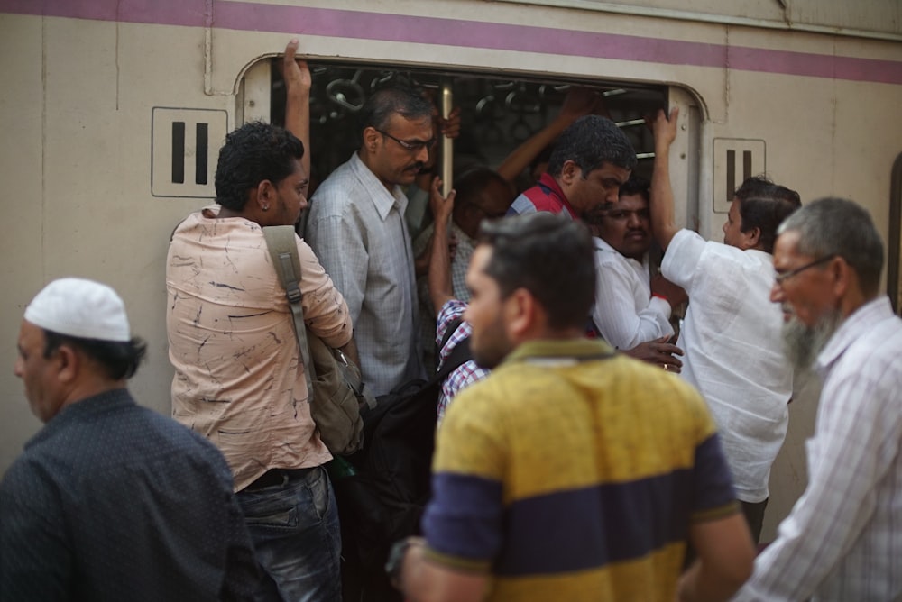 men walking out and in in train