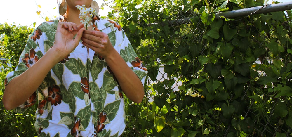 person in green and white floral button-up shirt