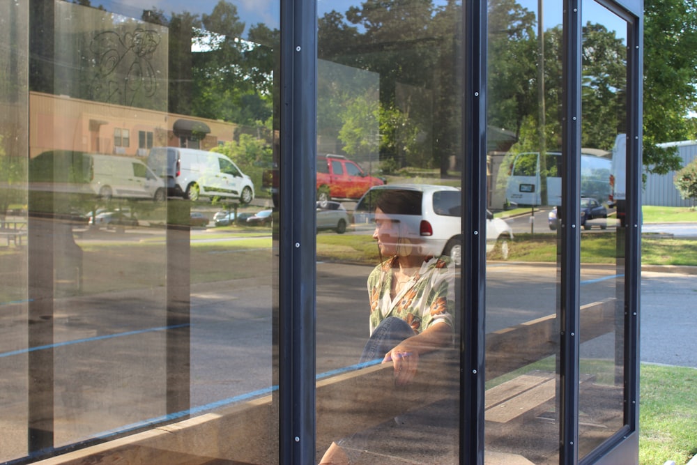 woman sits inside glass wall room