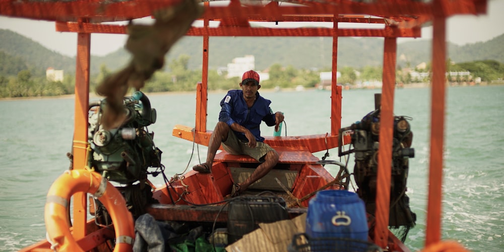 selective focus photography of man sitting on boat