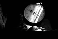 A side angle of the poster and clock setup, highlighting the contrast between light and shadow.