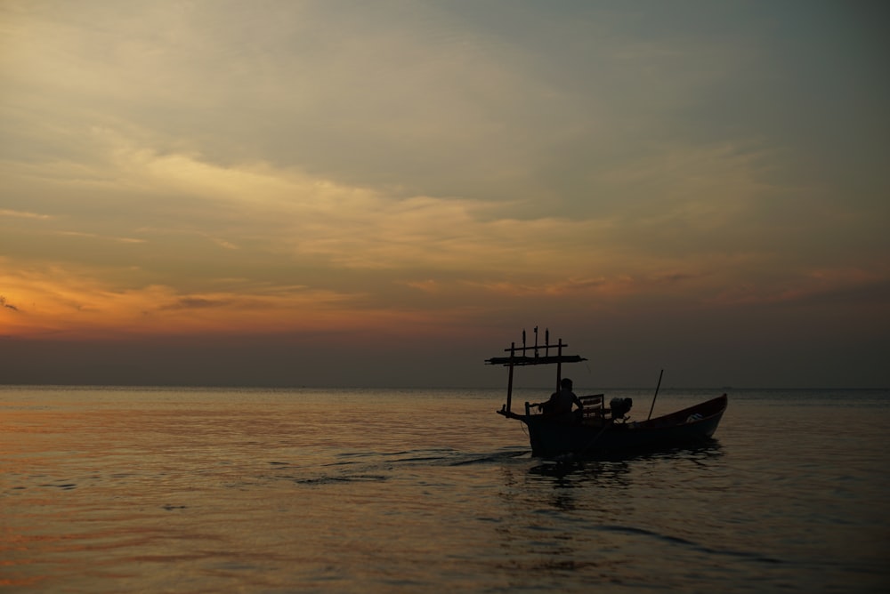 silhouette of man riding boat