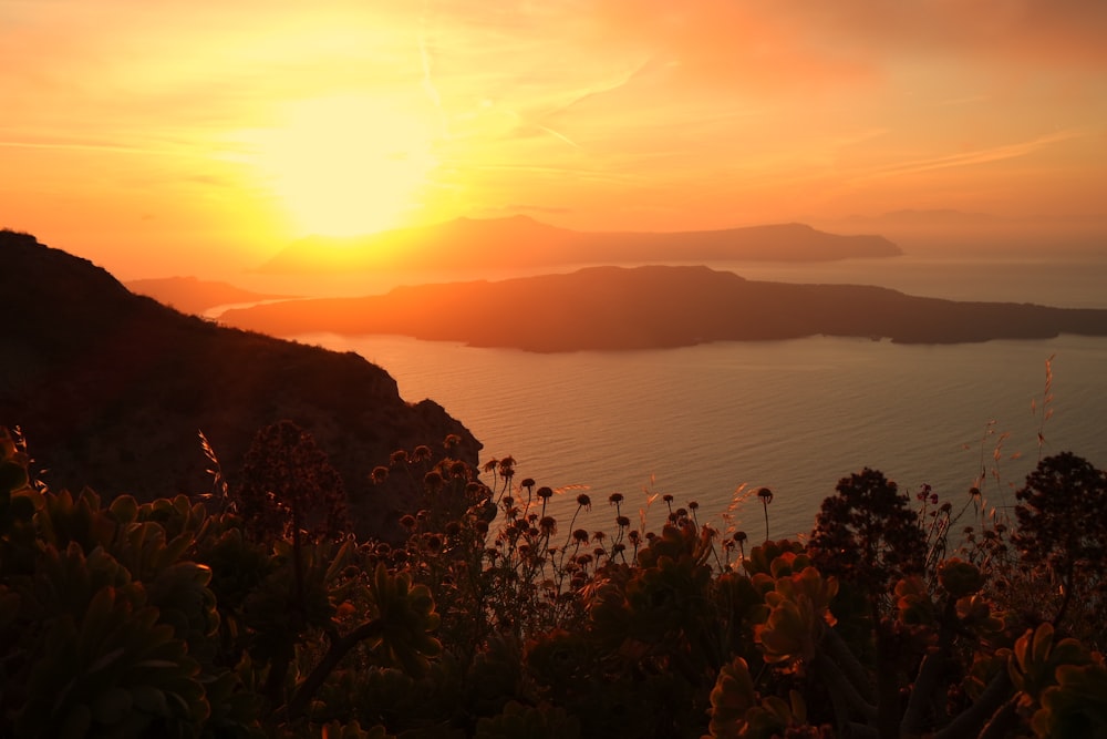 golden hour photography of mountain beside body of water