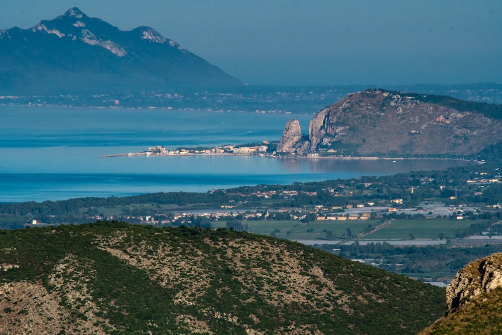 Montagne marroni e verdi vicino allo specchio d'acqua