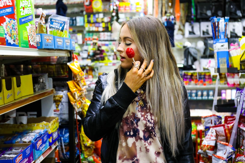 woman holding a red lollipop