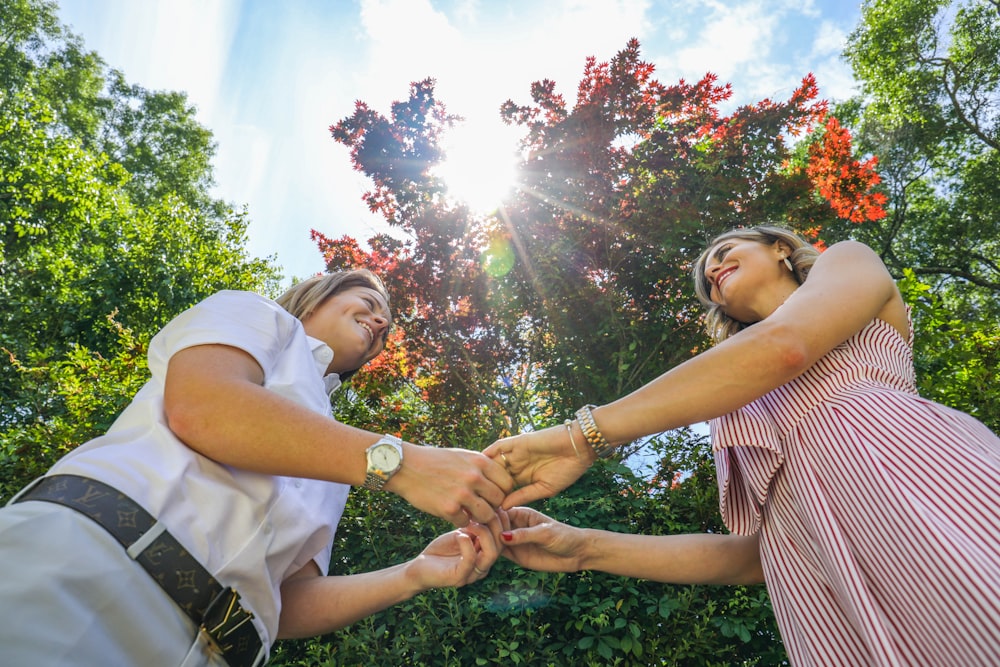 two woman standing holding hands