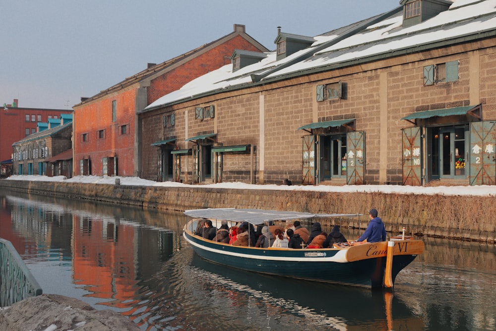 people riding on boat beside building