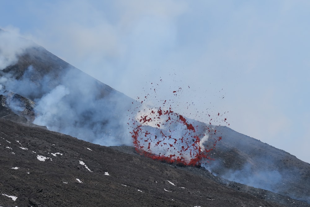 a red object is in the air near a mountain