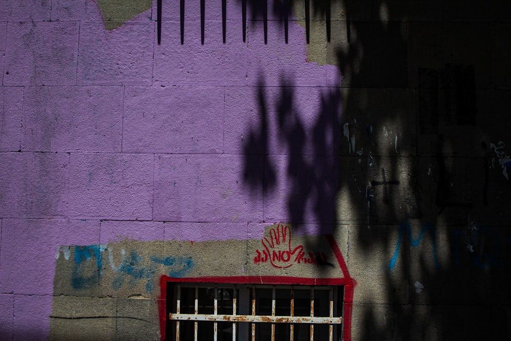 the shadow of a tree on a purple wall