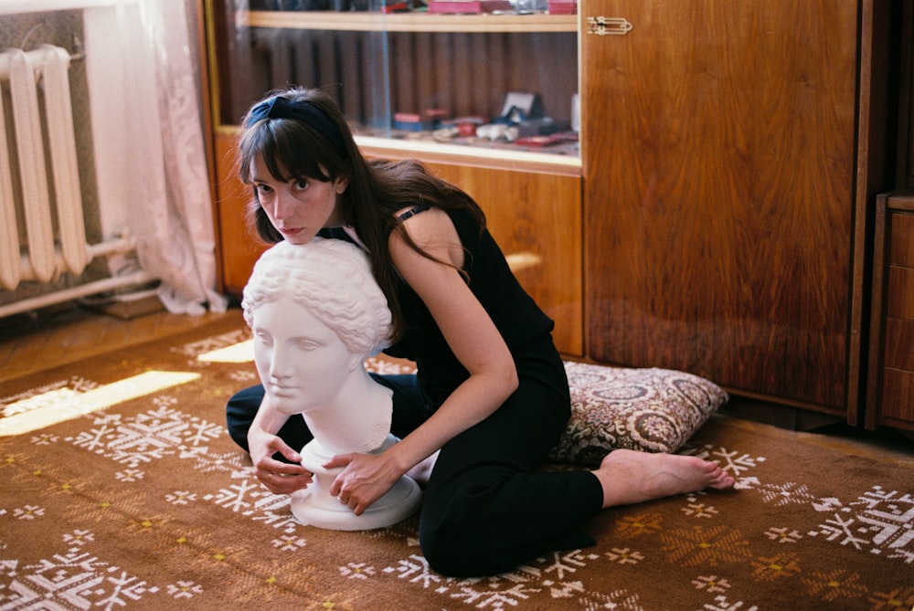 woman sitting on carpet hugging bust
