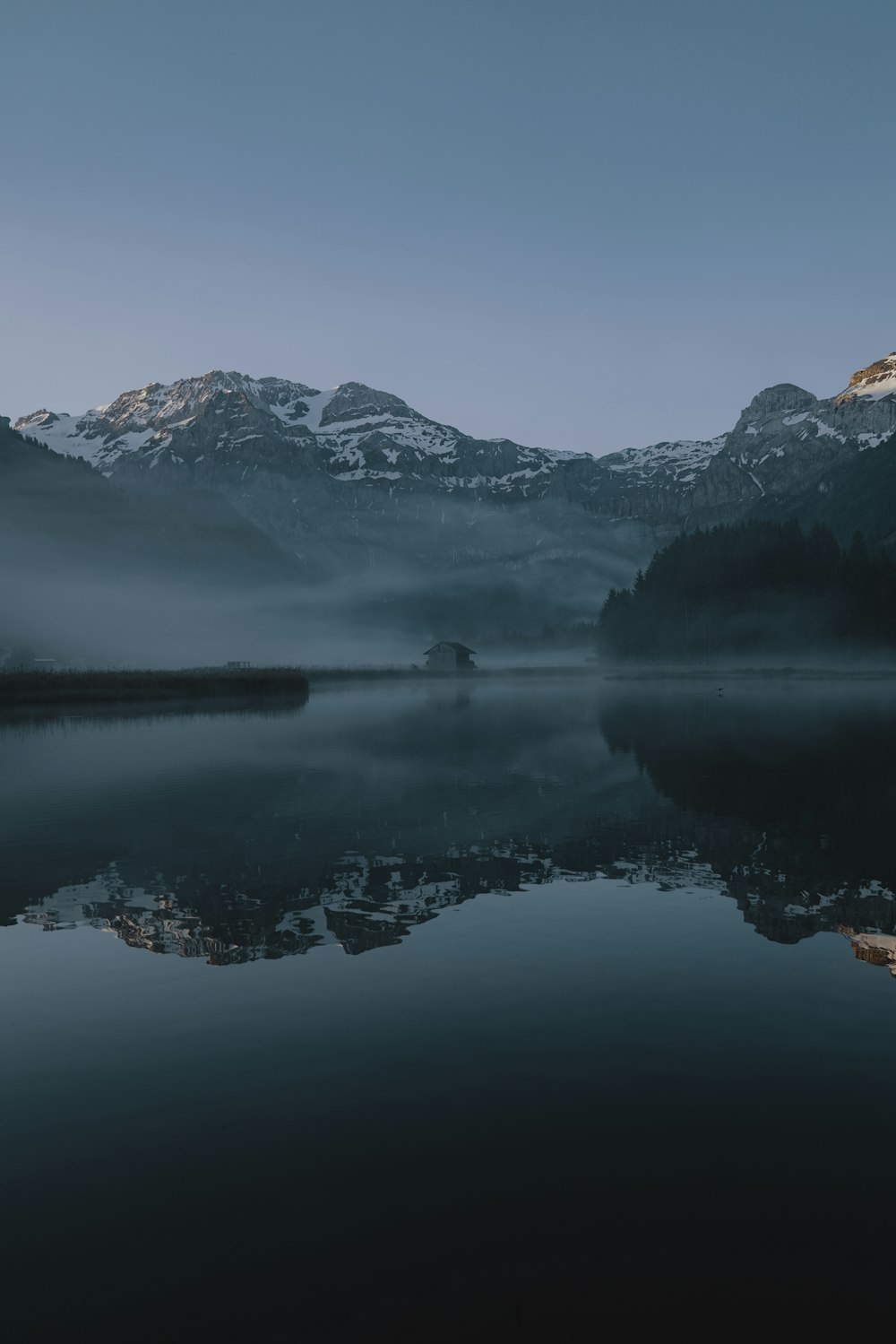 snow-covered mountain near body of water