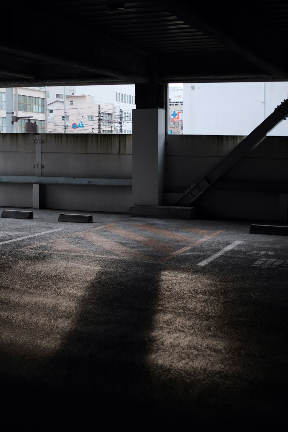 an empty parking lot with a ramp and a building in the background