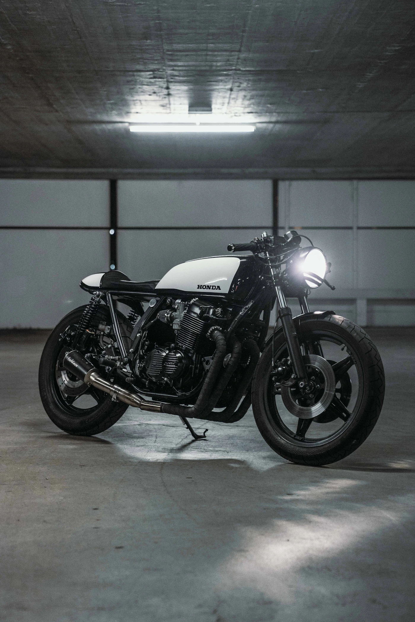 Silver-tanked cafe racer framed in an open garage doorway