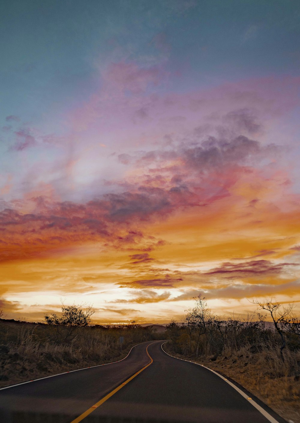 landscape photo of a road in the desert at sunset