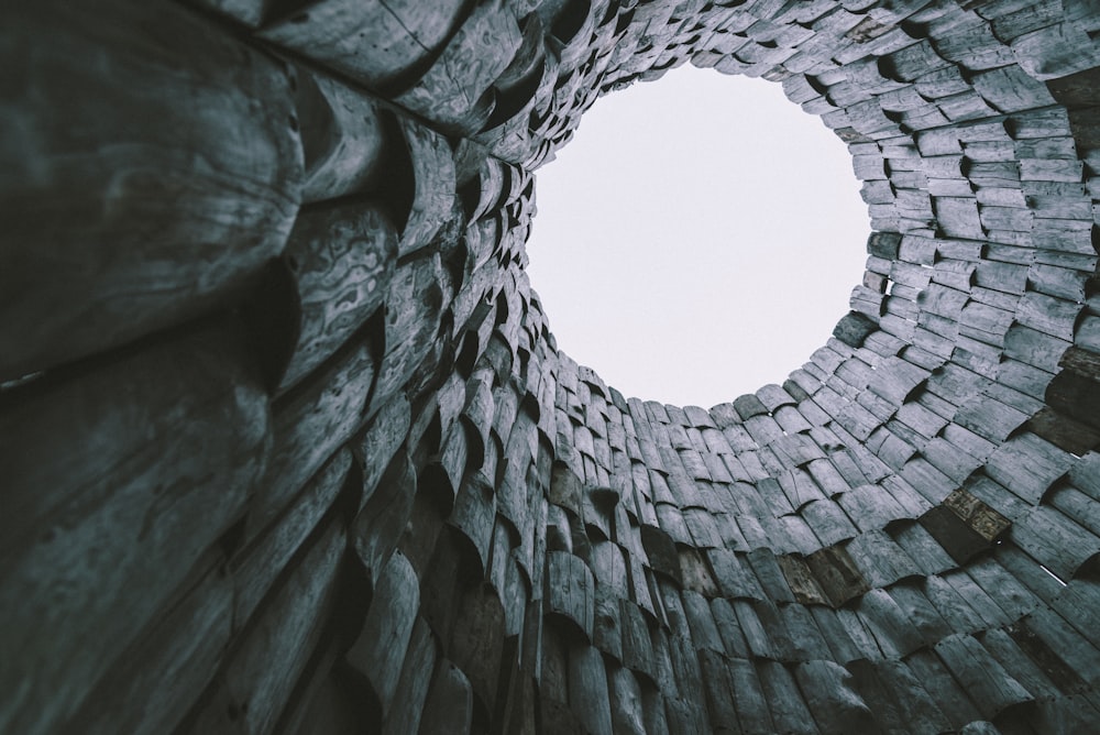 a round hole in a brick wall with a sky in the background