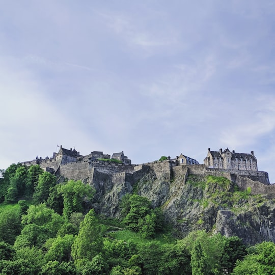 photography of castle on the top of mountain during daytime in Princes Street Gardens United Kingdom