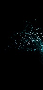 A dark background with glowing turquoise fiber optic strands fanning outwards, creating a captivating visual of shimmering lights and sparkling points.