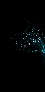 A dark background with glowing turquoise fiber optic strands fanning outwards, creating a captivating visual of shimmering lights and sparkling points.