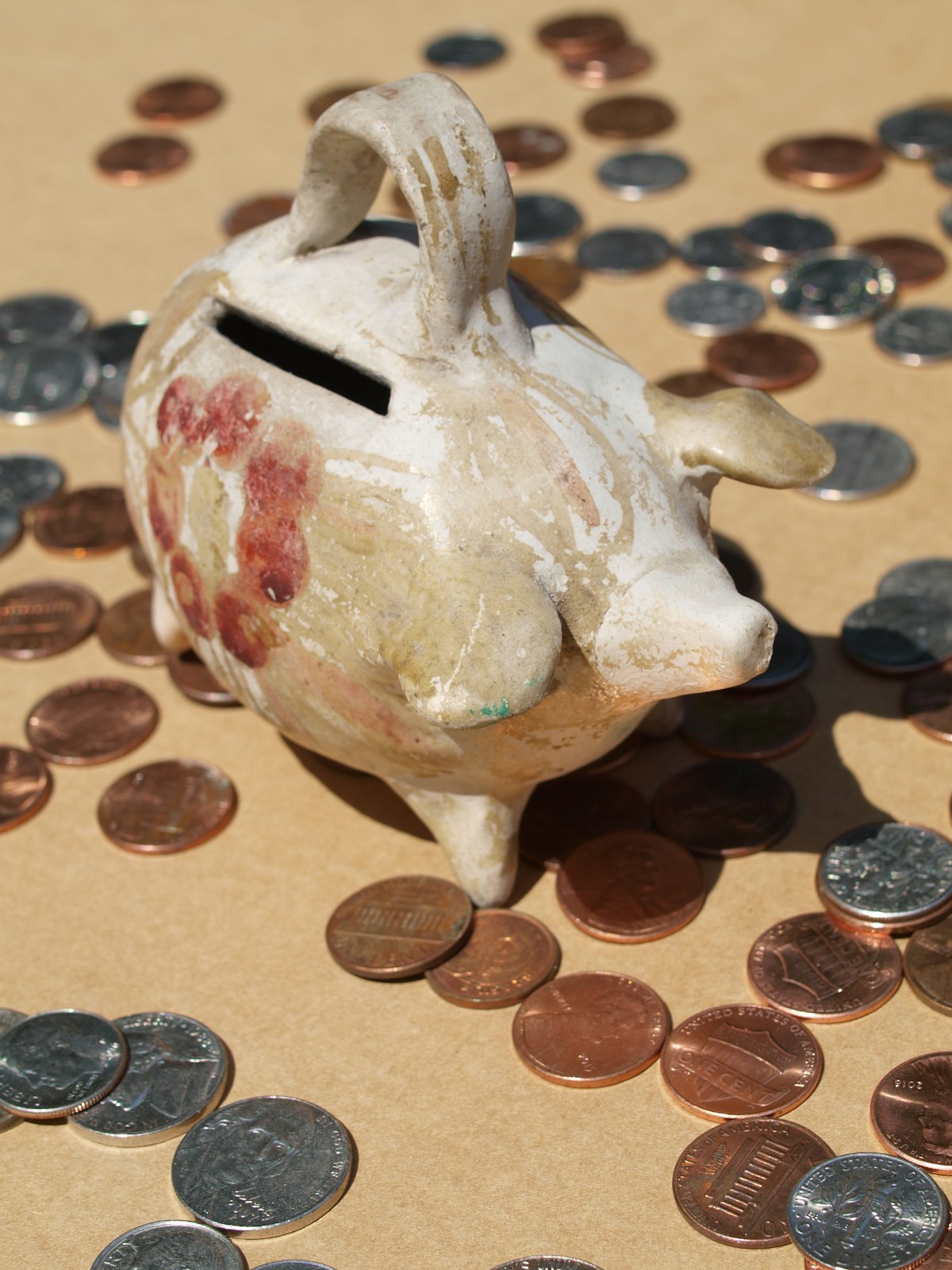 Vintage piggy bank with scattered coins representing retirement savings and 401(k) contributions