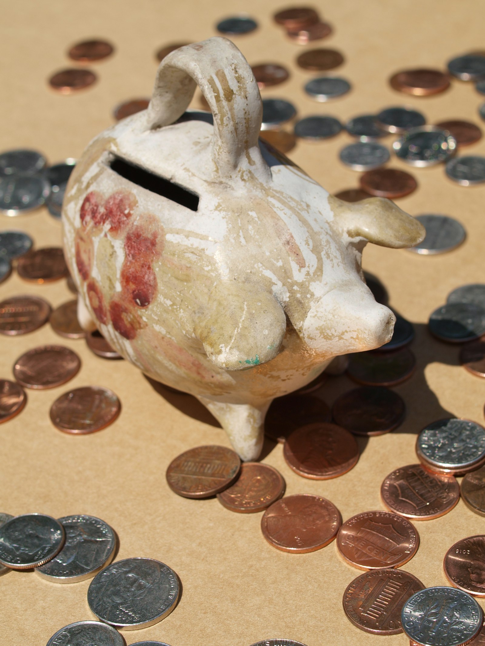 A worn ceramic coin bank on a plain surface