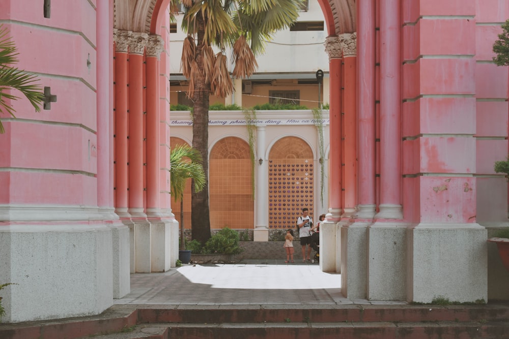 Edificio de hormigón rosa con pasarela de arco