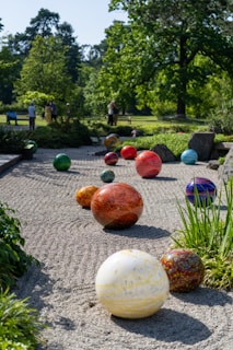 A serene outdoor space with art installations surrounded by greenery.